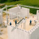 3D-печать дома на строительной площадке, работники в касках.