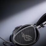 Наушники с микрофоном, освещённые на тёмном фоне.