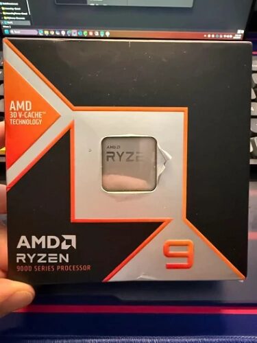 Упаковка процессора AMD Ryzen 9 с технологией 3D V-Cache на фоне клавиатуры.