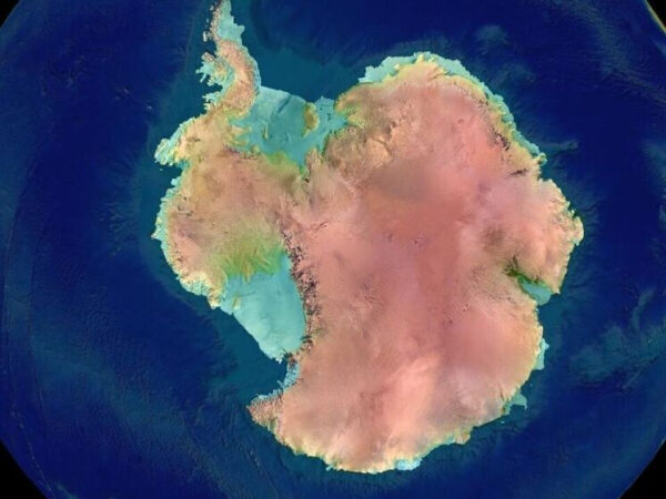 Спутниковый снимок Антарктиды, окутанной льдом, на фоне синего океана.