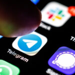 Палец нажимает на иконку приложения Telegram на экране смартфона.