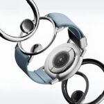 Современные умные часы с синим ремешком на светлом фоне.