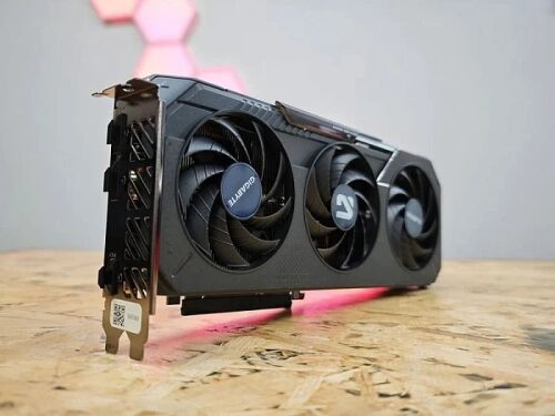 Видеокарта с тремя вентиляторами на деревянной поверхности, фон со светодиодами.