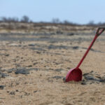 Красная лопата в песчаной пустыне, пасмурная погода.