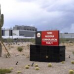 Завод TSMC в Аризоне с вывеской и пустынным пейзажем на фоне.