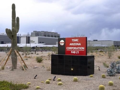 Завод TSMC в Аризоне с вывеской и пустынным пейзажем на фоне.