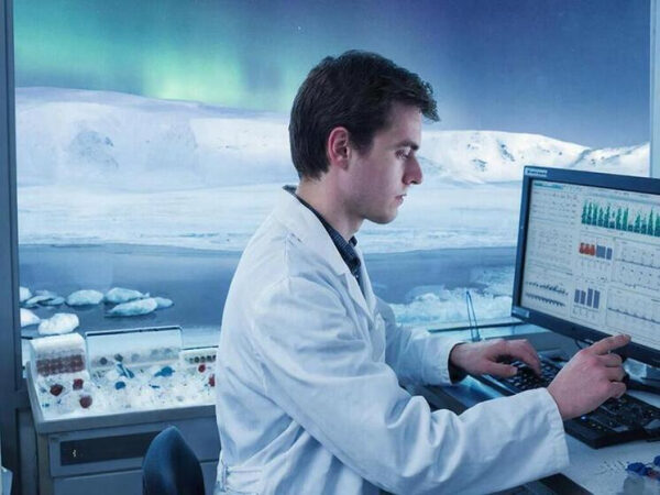 Учёный работает на компьютере в лаборатории, вид на Арктику и северное сияние.