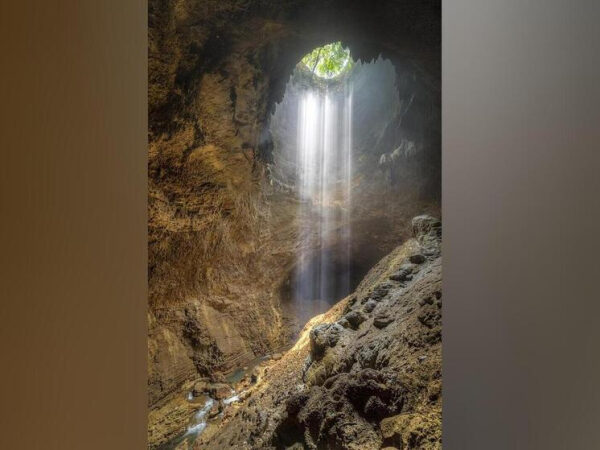 Свет в пещере через отверстие в потолке, создающий атмосферу природной красоты.