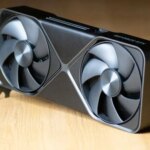 Видеокарта с двумя вентиляторами на деревянной поверхности.