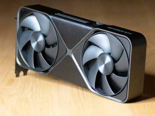 Видеокарта с двумя вентиляторами на деревянной поверхности.