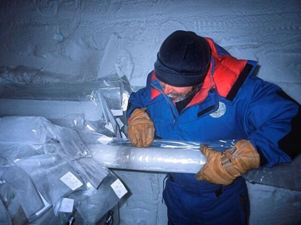 Человек изучает ледяной керн в антарктической лаборатории.