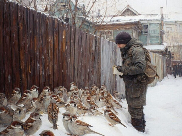 Всероссийская перепись воробьев пройдет с 7 по 15 февраля 3 Человек в зимней одежде кормит воробьев на заснеженной улице рядом с деревянным забором.