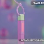 Брелок-пятновыводитель розового и зеленого цвета с фиолетовым фоном.