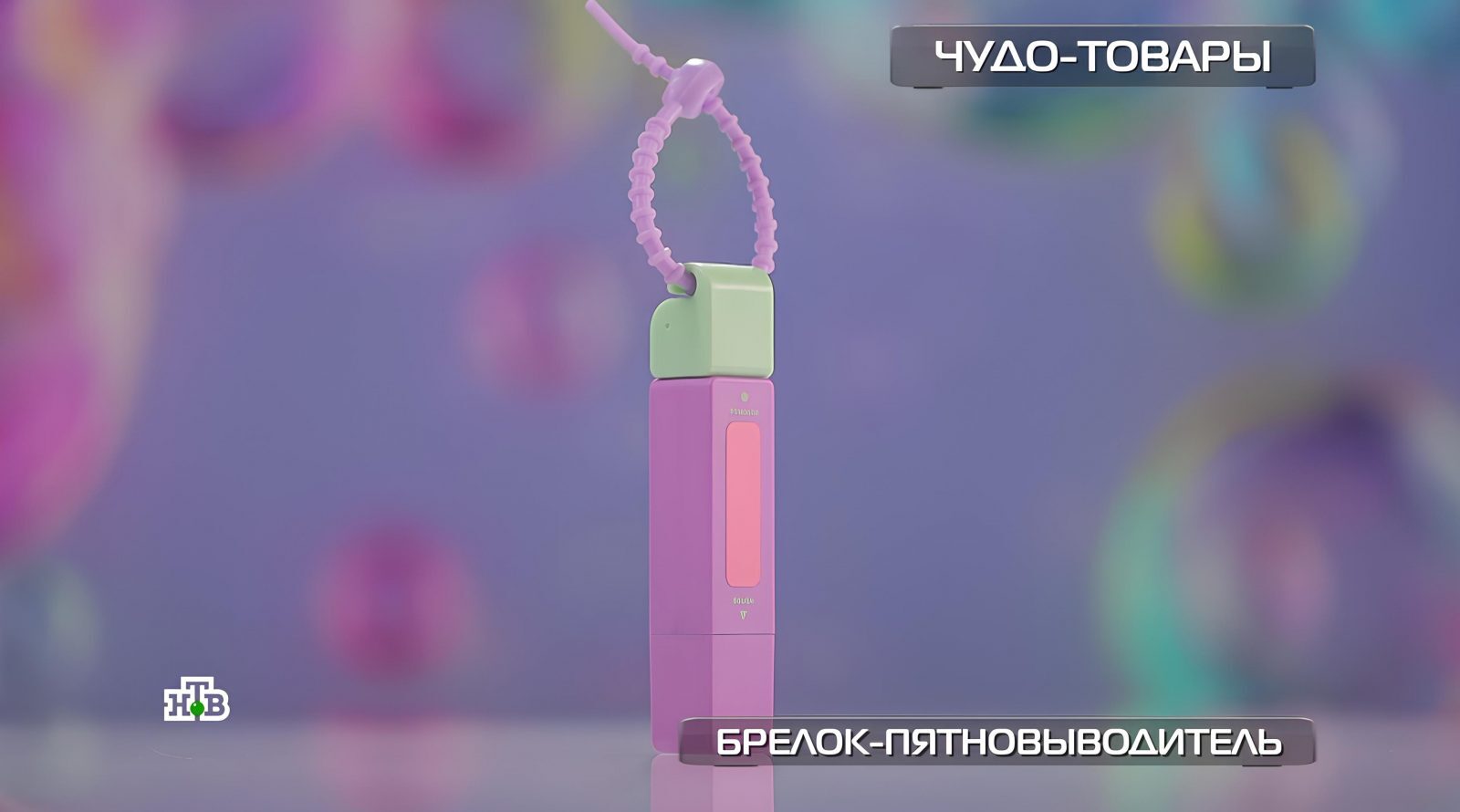 Брелок-пятновыводитель розового и зеленого цвета с фиолетовым фоном.