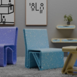 Современные разноцветные кресла и стол в интерьере с картинами и растением на полке.