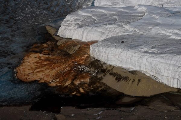 Ледник и камни на фоне воды, контраст природы.