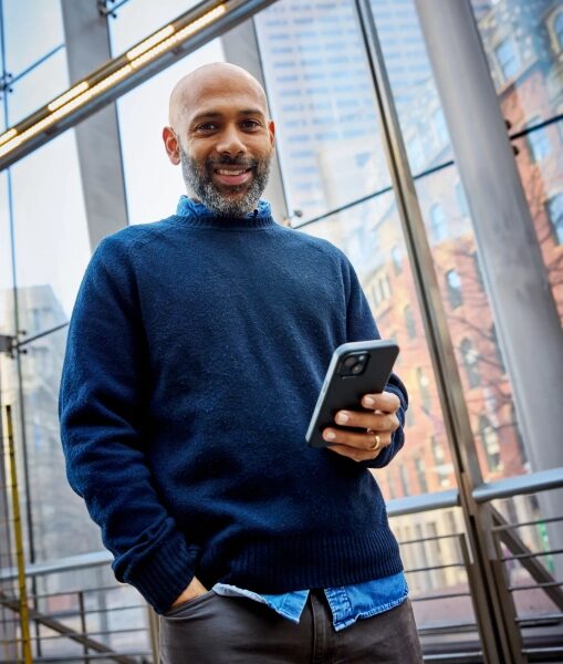 Карти Субрамайан идёт с телефоном в руках.