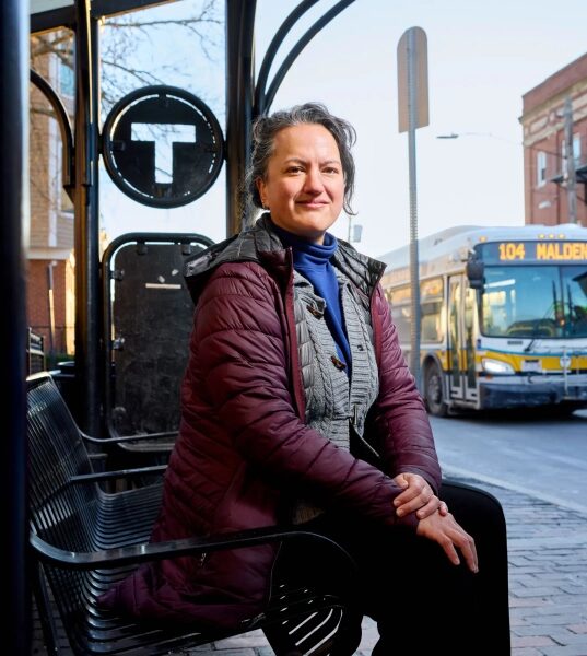 Мелисса Дуллеа сидит на автобусной остановке рядом с автобусом № 104, следующим в Малден.