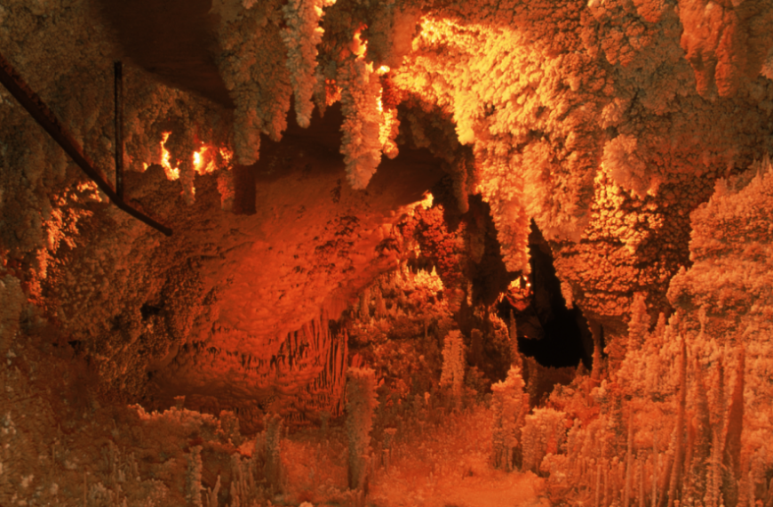 Огненное свечение в пещере с соляными сталагмитами и сталактитами.