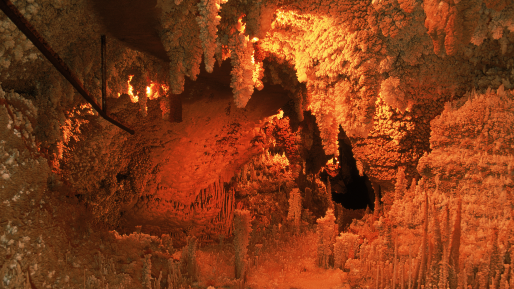 Огненное свечение в пещере с соляными сталагмитами и сталактитами.