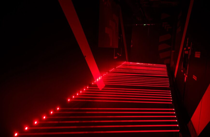 Неоновый красный свет в темном коридоре, создающий футуристическую атмосферу.
