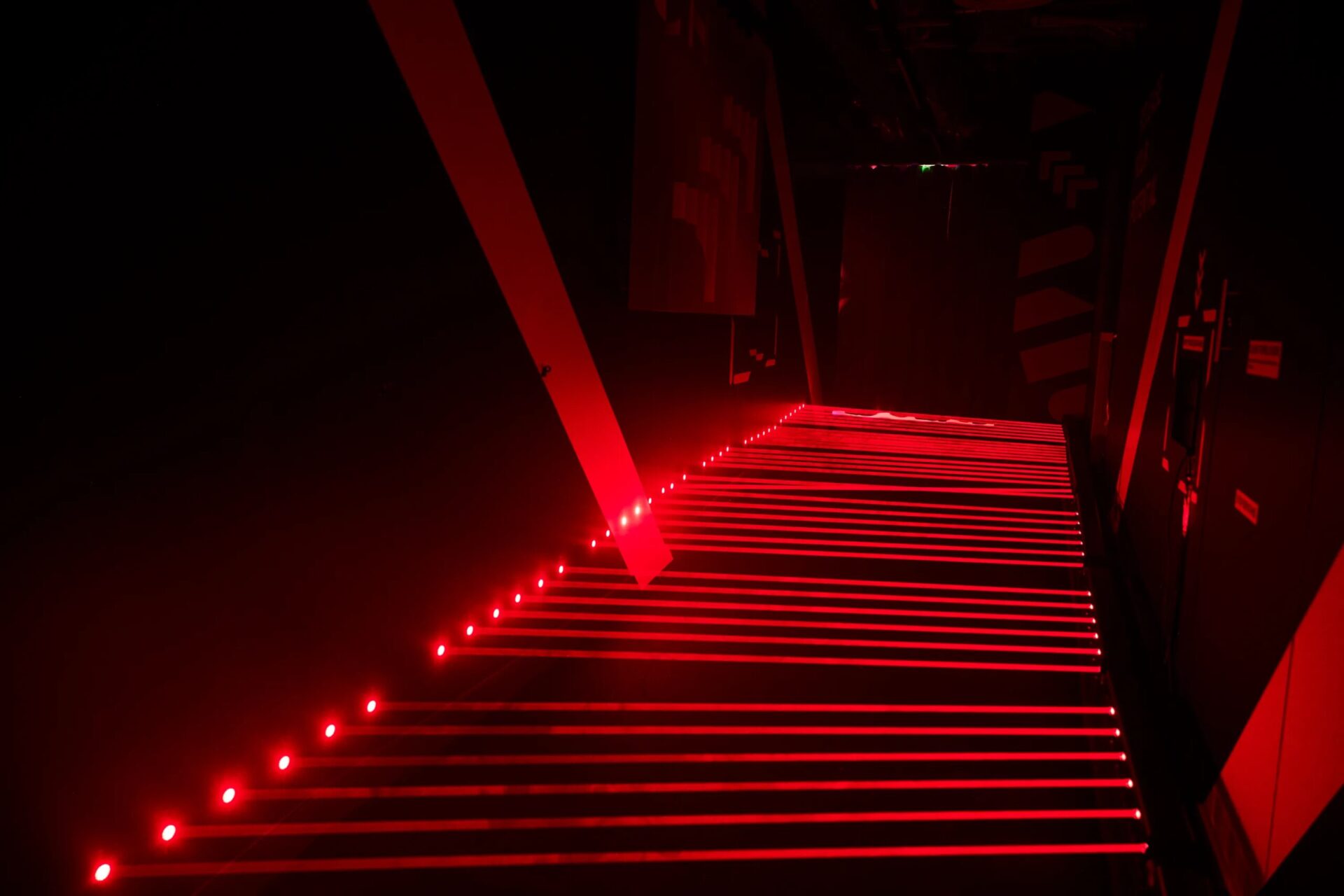 Неоновый красный свет в темном коридоре, создающий футуристическую атмосферу.