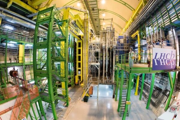 Экспериментальная установка LHCb в ЦЕРНе с зелеными и желтыми металлическими конструкциями.