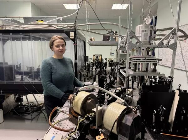 Женщина в лаборатории рядом с научным оборудованием.