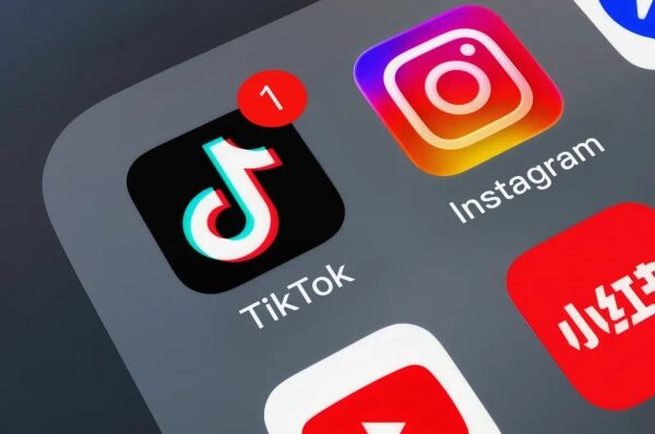 Иконки приложений TikTok и Instagram на экране смартфона, уведомление на TikTok.