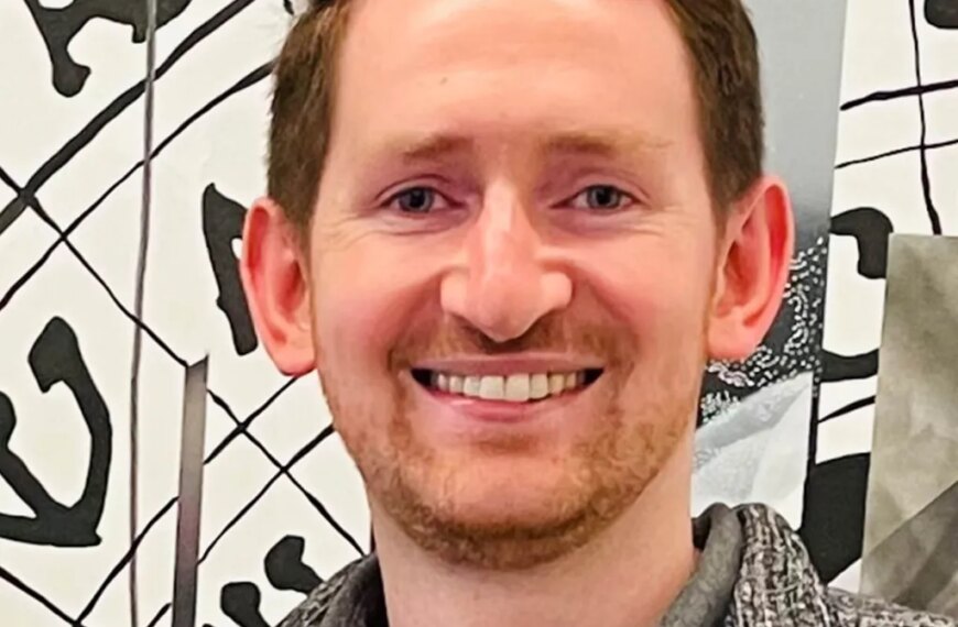 Изображение улыбающегося мужчины на фоне художественного рисунка.