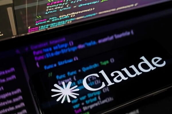 Экран с логотипом "Claude" на фоне кода программирования на компьютере.