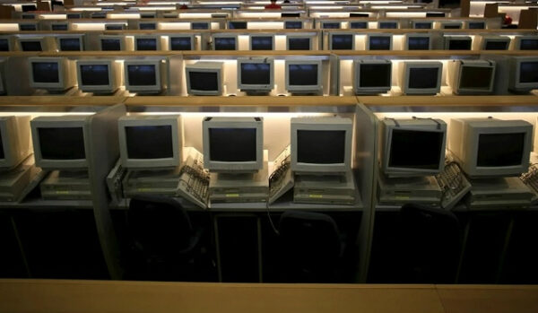 Ряды старых ЭЛТ мониторов в пустом офисе, устаревшая компьютерная техника.