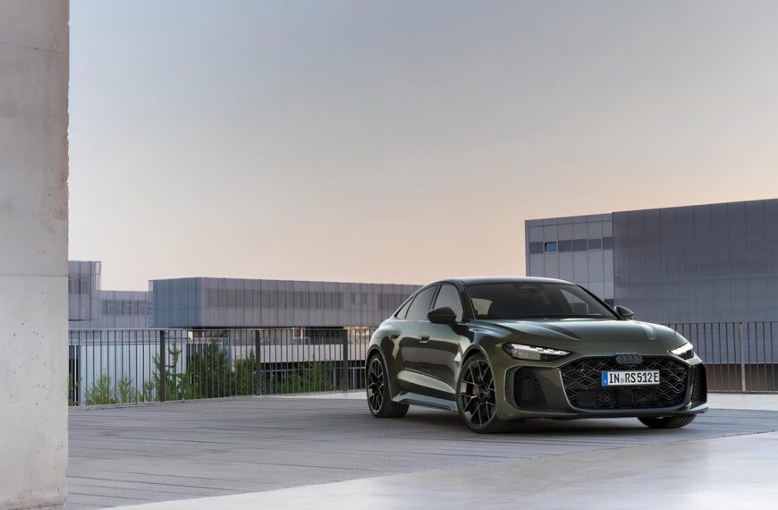 Спортивный автомобиль на фоне современного здания под вечерним небом.