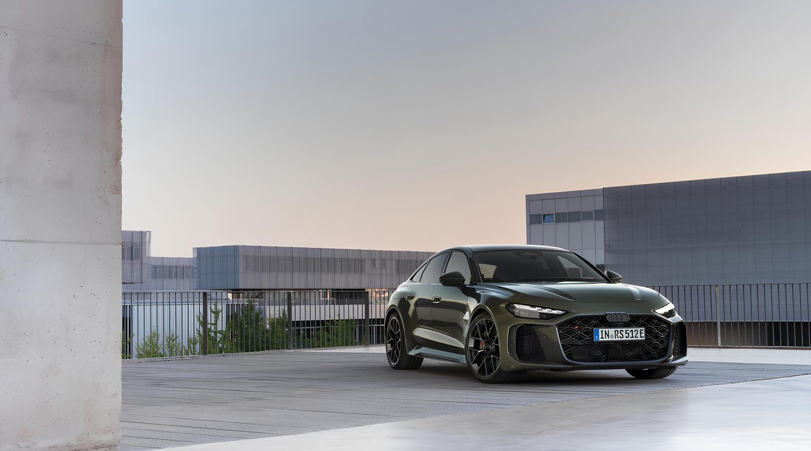 Спортивный автомобиль на фоне современного здания под вечерним небом.