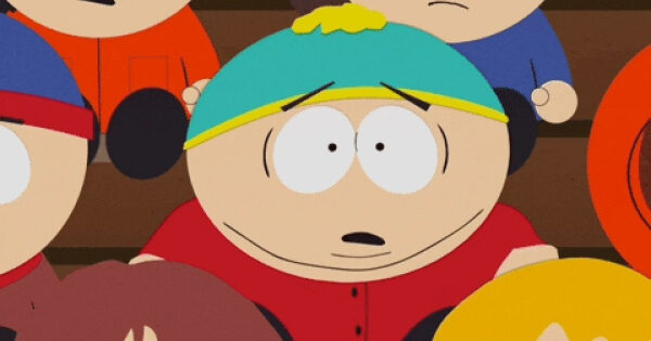 Мультяшный мальчик в красной рубашке и голубой шапке, сидит среди других детей.