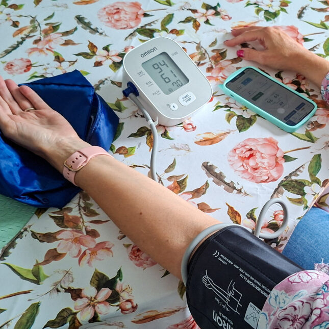 Измерение артериального давления тонометром на руке, данные на смартфоне и приборе.