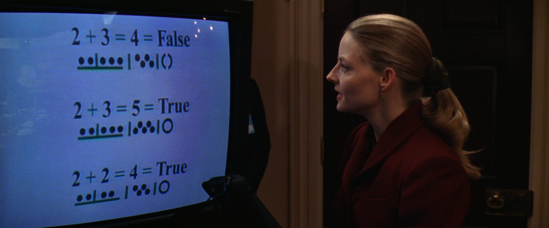 Изображение учёного, стоящего перед телевизором, на экране которого отображаются математические формулы.