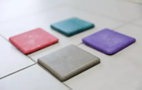 Четыре цветные плитки на светлом полу: красная, зелёная, синяя и серая.