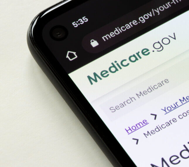 Смартфон с открытым сайтом Medicare.gov на экране, онлайн-сервис здравоохранения.