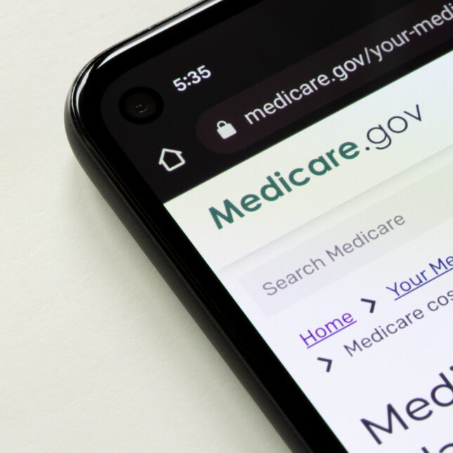 Смартфон с открытым сайтом Medicare.gov на экране, онлайн-сервис здравоохранения.