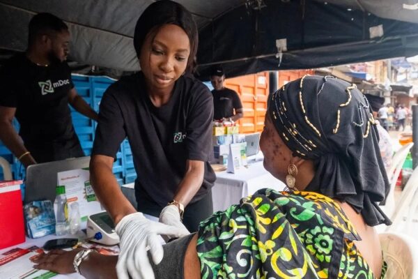 Медицинская помощь: врач измеряет давление женщине на улице.