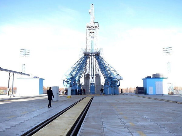 Космическая площадка с пусковой установкой для ракет на фоне голубого неба.