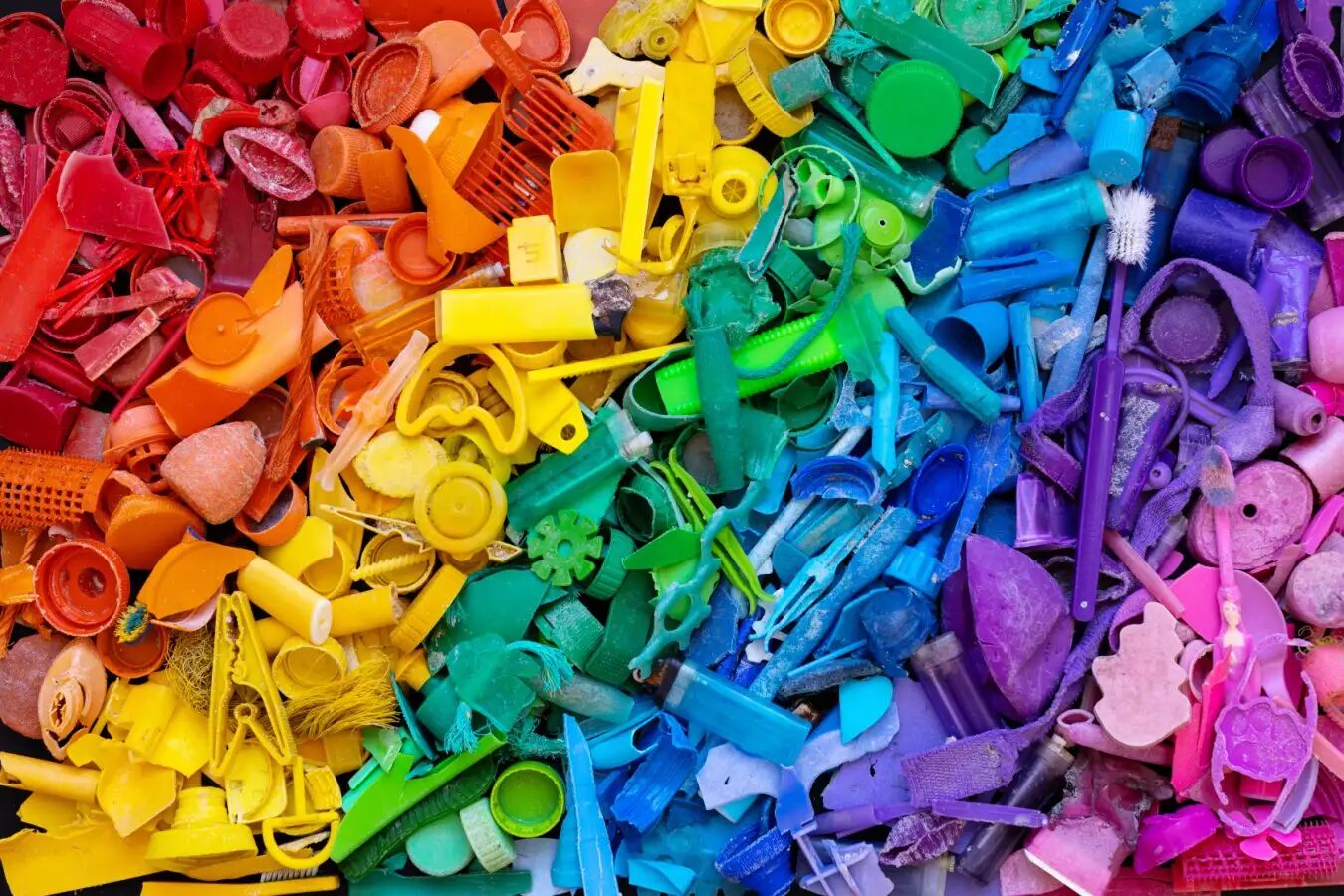 Пластиковые отходы, выложенные в радугу для сортировки и переработки.