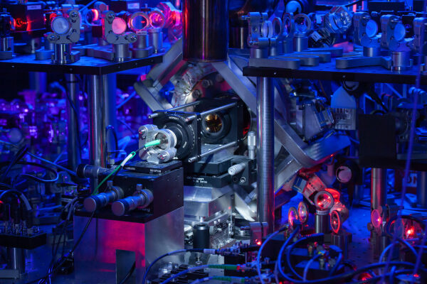 Фотография сложного механизма, подсвеченного синими и красными огнями.