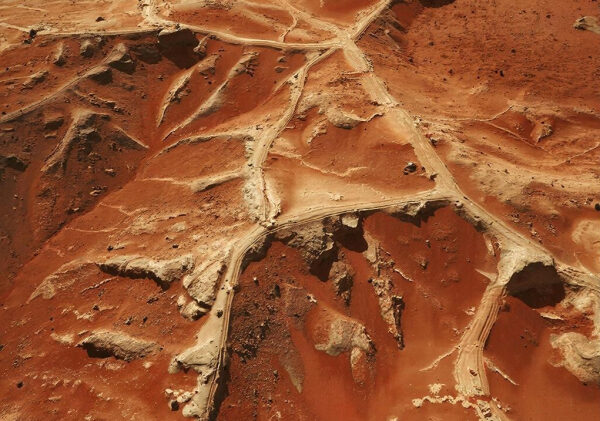 Красные марсианские ландшафты с серыми тропинками, напоминающими поверхность Марса.