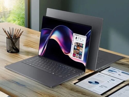 Ноутбук на деревянном столе в офисе, открытый экран с графиками и документами рядом.