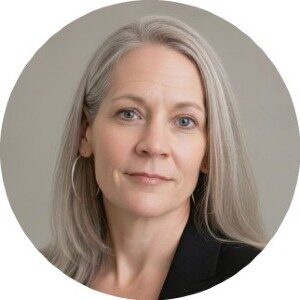 Изображение женщины с длинными седыми волосами в чёрной одежде на сером фоне.