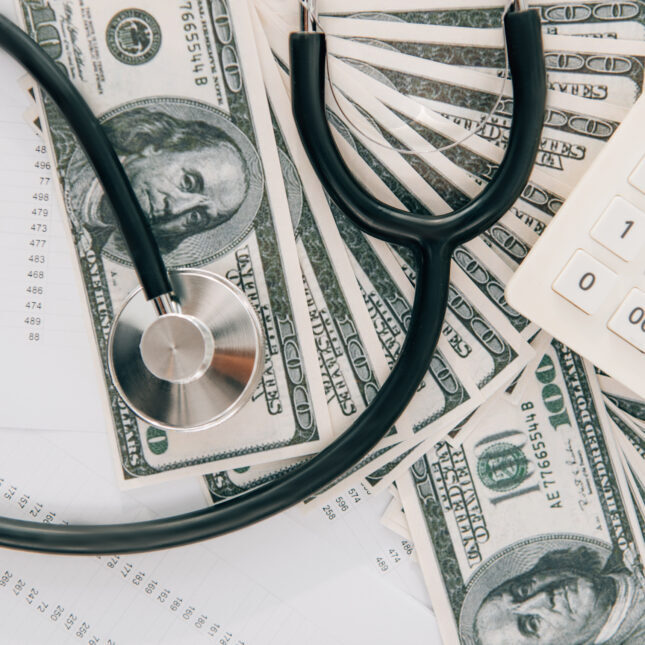 Стетоскоп на долларах и калькулятор — концепция медицинских расходов.