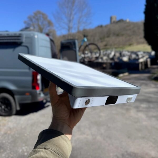 Усовершенствованная портативная радиостанция Starlink Mini с питанием от батареи уже здесь! 2 Рука держит антенну Starlink на фоне природы и фургонов.