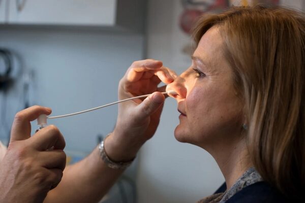 Пациентка на приеме у врача-отоларинголога в медицинском кабинете.